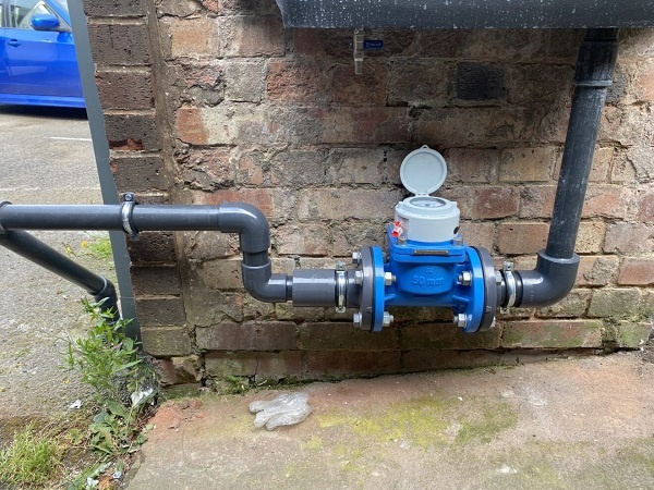 Photograph of a discharge pipe we modified to include the addition of a water meter to record the amount of product discharge to a sewer.