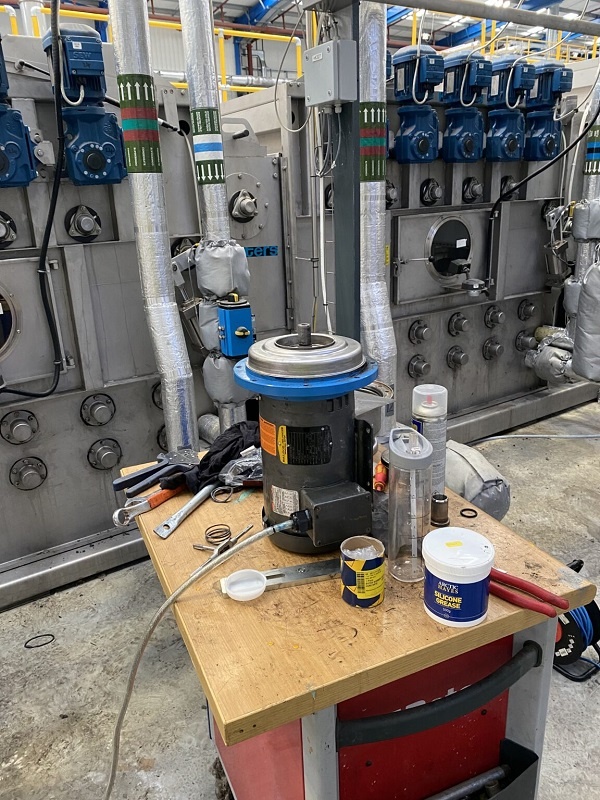 Photograph shows the pump stripped down on a work table as it is rebuilt. The pump is a critical part of the process filtration system.